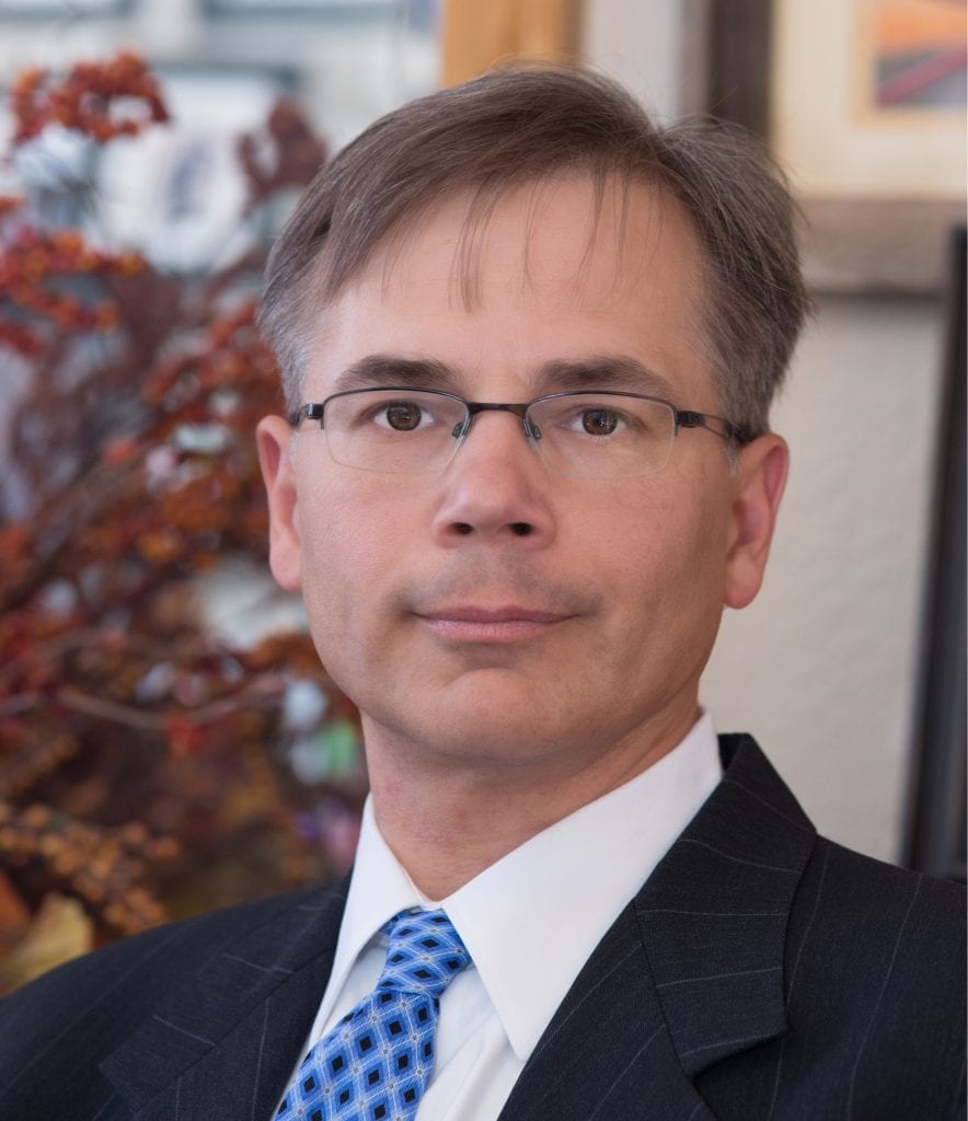 Dr. Kirk is an aviation psychiatrist in Denver and Las Vegas. The picture shows Dr. Kirk in his Denver office wearing a black suit and blue tie.